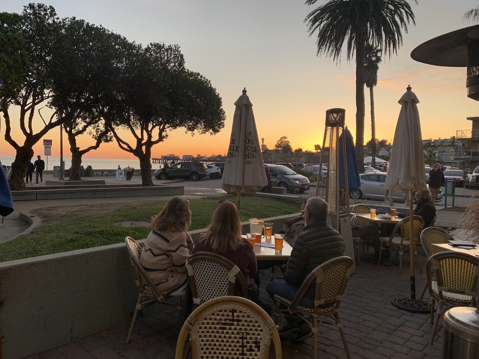 Pub tables beside ocean-view windows.